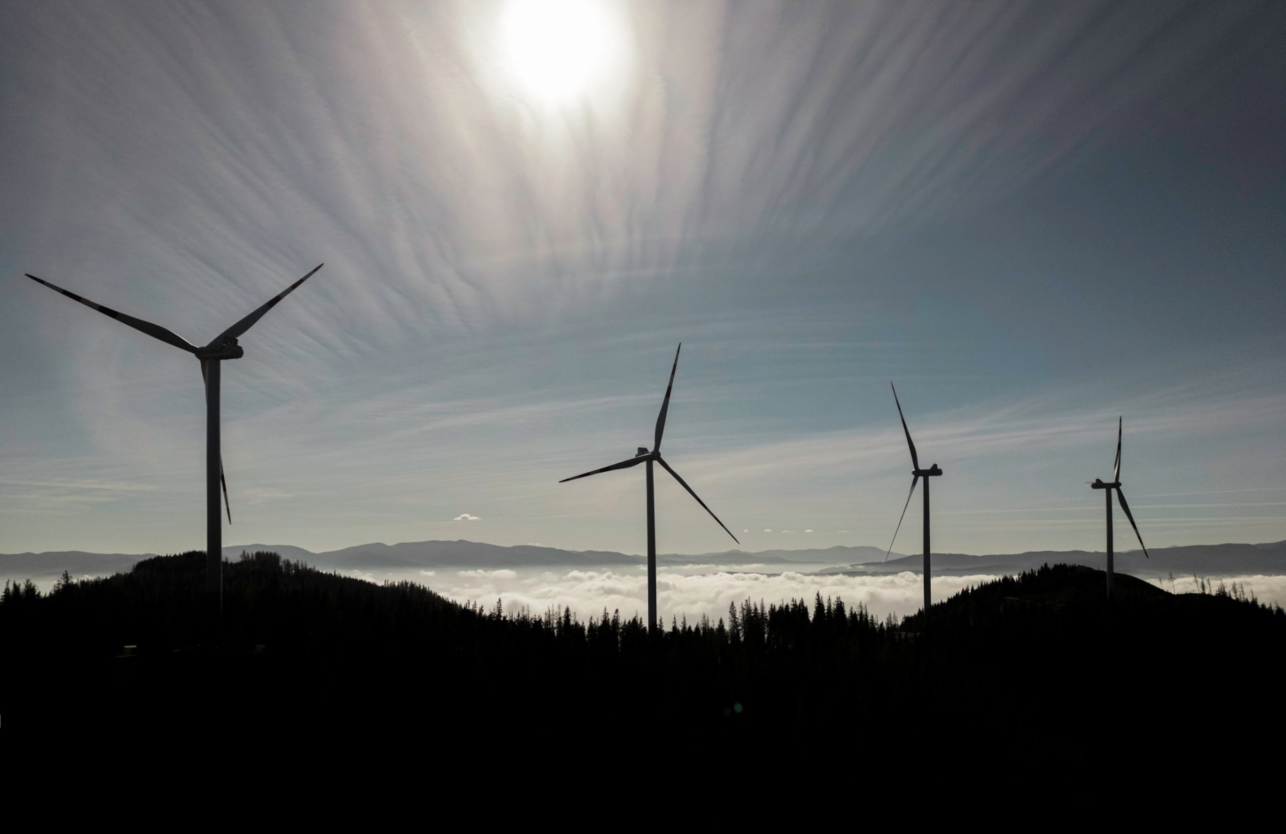 Die Windräder der Windparks Silbersberg im Gegenlicht, die Sonne bescheint den Nebel, der über dem Tal liegt
